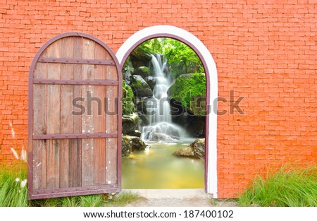 Old door wooden is open to waterfall wall