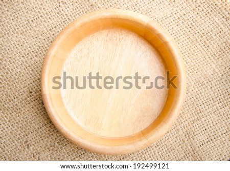 empty wooden bowl on sack background