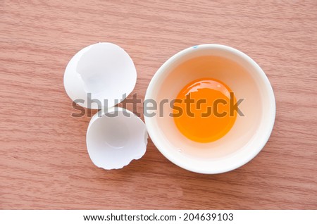 Fresh duck egg in cup on wood background