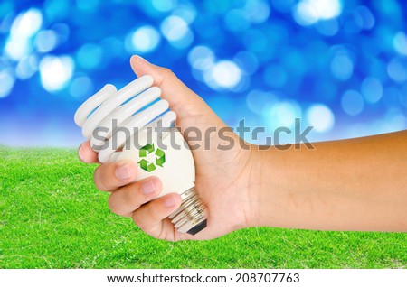 Hand with lamp and sign recycle on spring background