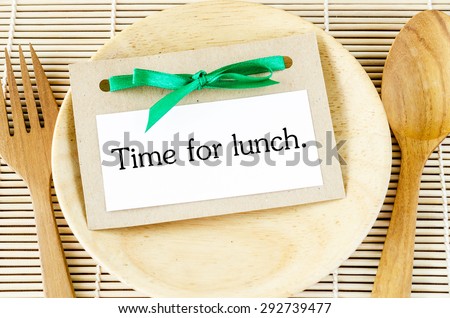 Time for lunch in card on wooden dish and spoon