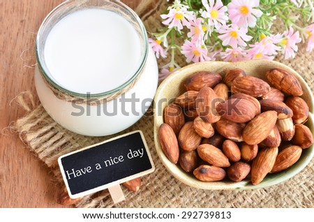 Have a nice day with almond and almond milk on sack background.