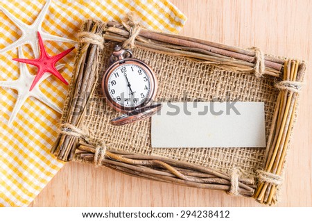 Blank paper tag for you text and vintage pocket watch on wooden background.