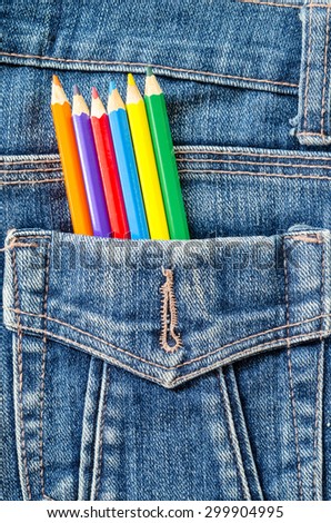 Artist painting concept. Many color pencil in blue jeans pocket background.