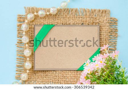 Blank brown tag paper recycle with flower on sack background for your text.