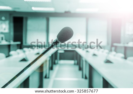 before a conference, the microphones in front of empty chairs in meeting room.
