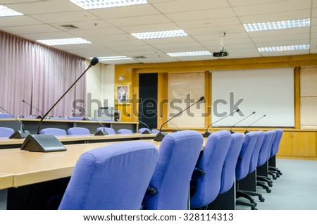 before a conference, the microphones in front of empty chairs in meeting room.