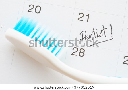 Dentist appointment date on calendar with toothbrush.