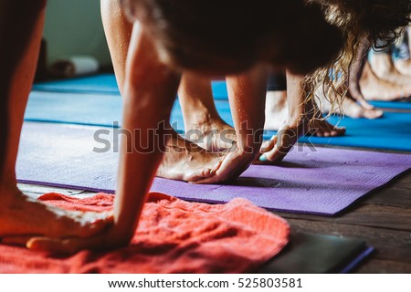 Women practicing yoga and meditation in retreat studio class during Bali vacation recreation