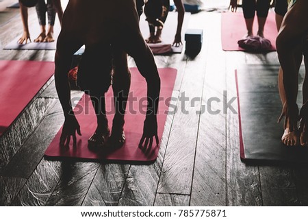 Sweating people practicing yoga during retreat in studio