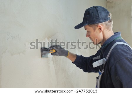 Man gets manually gypsum plaster on the wall