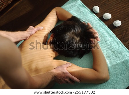 man makes  woman back and shoulder massage