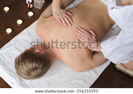 Back Massage. Woman doing massage to man. Her hands on his back