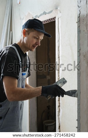 Man gets plaster to secure the guide to align the walls in the future
