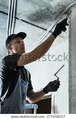 Man gets plaster to secure the guide to align the walls in the future