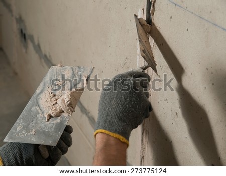 Man fixes a guide to align the walls with stucco in the future