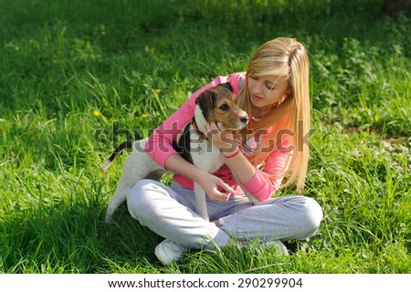 Beautiful girl and fox terrier sitting nearby. Girl petting dog