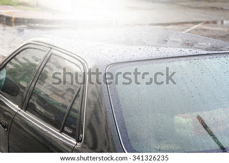 Raindrops on a car surface,Car wash, black car in automatic car wash soft focus