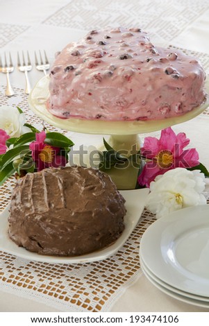 Chocolate Cake and Berry Cake on a Table with Flowers from Above