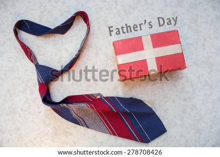 Fathers Day gifts with tag and tie over a white background
