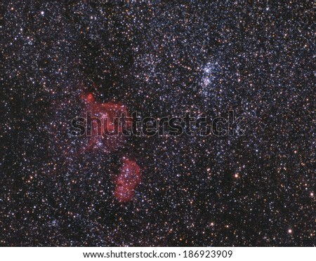 Clusters of stars and some red hydrogen nebulae in interstellar space between the constellations of Cassiopeia and Perseus.