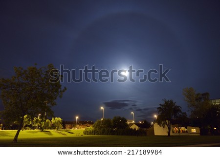 A 22 dergree halo around the Moon in an urban scene. The halo is caused by ice crystals in the atmosphere.