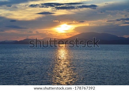 A view from the Greek island of Hydra, as the setting sun casts a channel of light across the sea.