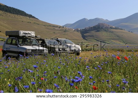 Castelluccio di Norcia, Italy - July, 12 - Fiat Panda in the middle of fields and flowers in Piano  grande on July, 12, 2015. Castelluccio di Norcia, Italy