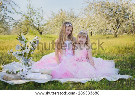 Two little cute girls in pink dresses