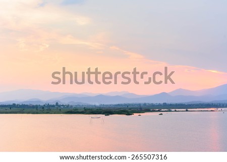 photo view of lake with mountain against sunset sky