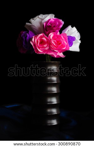 paper flowers in wooden vase ( focus on vase) on black background