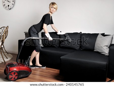Cleaning lady vacuuming couch