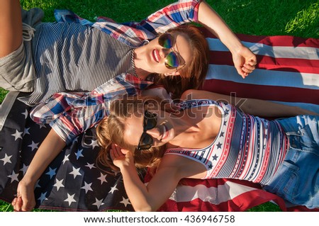 Young happy patriot women celebrating independence day  4th of july on the united states flag