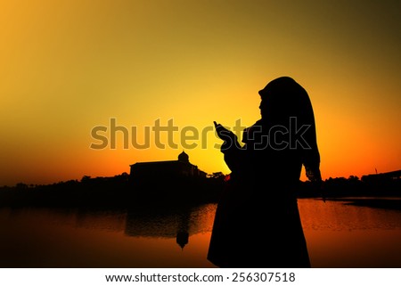 silhouette of a muslim woman praying on the Mosque