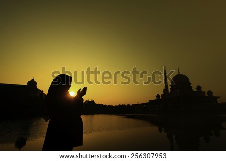 silhouette of a muslim woman praying on the mosque