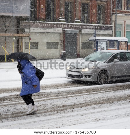 Birmingham, United Kingdom - November 18, 2010: Woman With An Umbrella Bracing The Snow Storm During The 2010 Winter In Birmingham, Uk. The Snow Brought Widespread Travel Disruption.