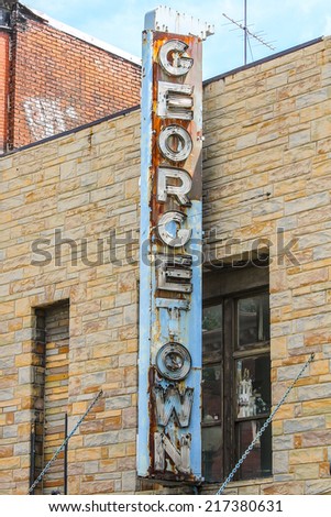 Rusty vintage Georgetown sign hanging from a brick wall  in Washington DC