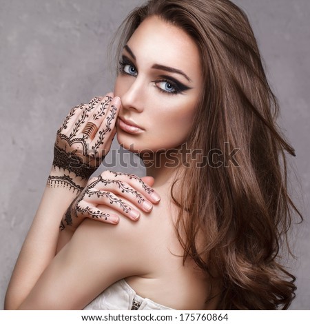 Beautiful young lady with painted hands mehendi. Beauty photo