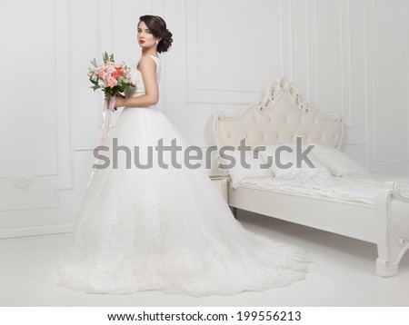 Beautiful sensual brunette with elegant hairstyle. Wedding dress. Fashion photo