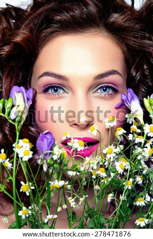 Portrait of beautiful young woman with flowers. Perfect makeup. Perfect skin. Fashion photo