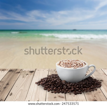 Cup of coffee with coffee beans on table with sea