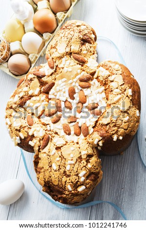Colomba - italian easter dove cake on old rustic white wooden board.