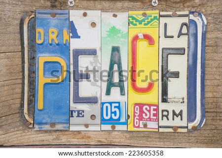 Peace sign made out of different state license plates nailed to wood