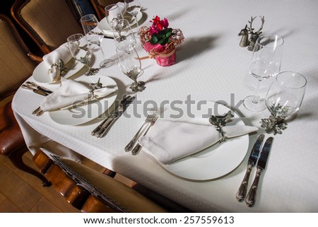 Decorated table in the restaurant covered with a white tablecloth