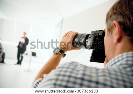 The photographer takes pictures of people in a professional photo studio