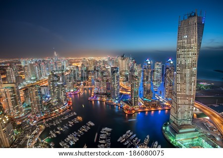 Dubai Marina at Blue hour, Glittering lights and tallest skyscrapers during a clear evening with Blue sky.