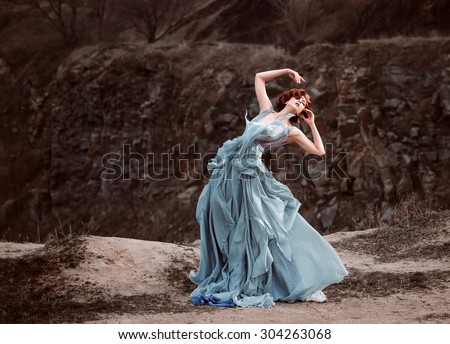 Beautiful girl dancing on the background of rocks.  It Fancy Dress in the style of Shabby Chic. Fashionable toning.