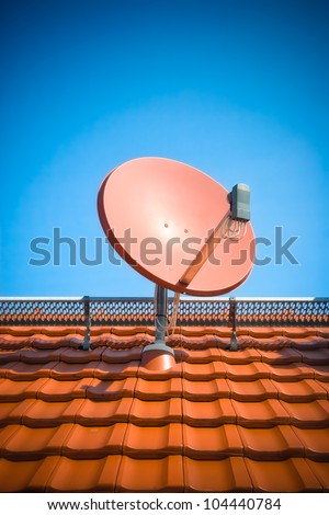 Satellite dish on roof with clear blue sky