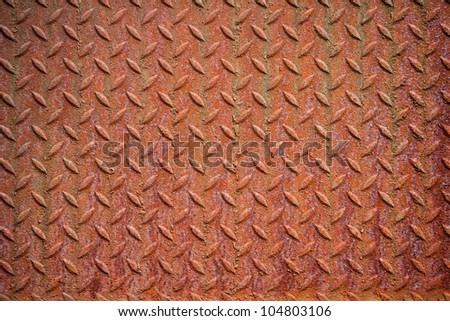 Photography shows a rusty metall background with diamond pattern.