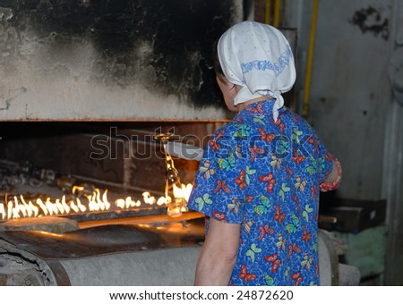 Glass blower heating the glass in oven